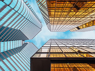 low-angle photography of glass high-rise buildings under blue sky and white clouds at daytime