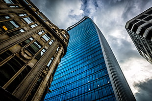 blue glass tower under white cloud-covered blue sky