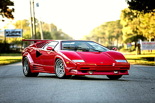 classic red Lamborghini sports car parked on concrete road