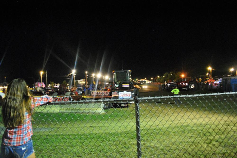 Girl watching tractor pulling event at the Centre County Grange Fair in Centre County, Pennsylvania. 