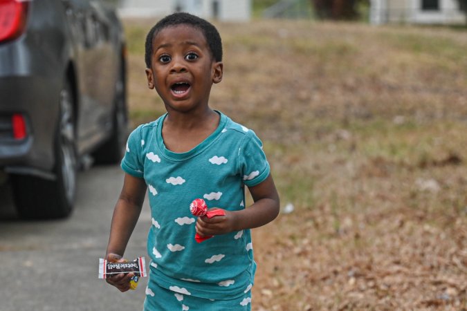 A child holds candy during the Month of the Military Child (MoMC) parade through base housing at Little Rock Air Force Base, Arkansas, April 1, 2024. During the month of April, events like Purple Up! Day, where communities are encouraged to wear purple, are held in support of MoMC. (U.S. Air Force photo by Airman 1st Class Saisha Cornett)