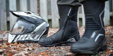 Woman wearing Joe Rocket boots before spring ride with helmet nearby