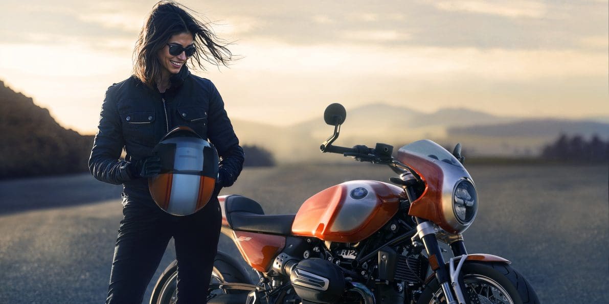 A woman standing next to a BMW bike.