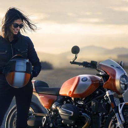 A woman standing next to a BMW bike.