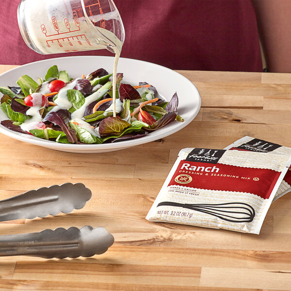 A bowl of salad with Foothill Farms Ranch dressing being poured into it.