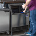 A person holding a glass of ice from a Manitowoc undercounter ice machine.