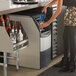 A woman pouring water into a Scotsman undercounter ice machine.