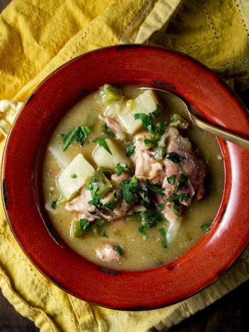 Overhead of southern stewed chicken in a red bowl.