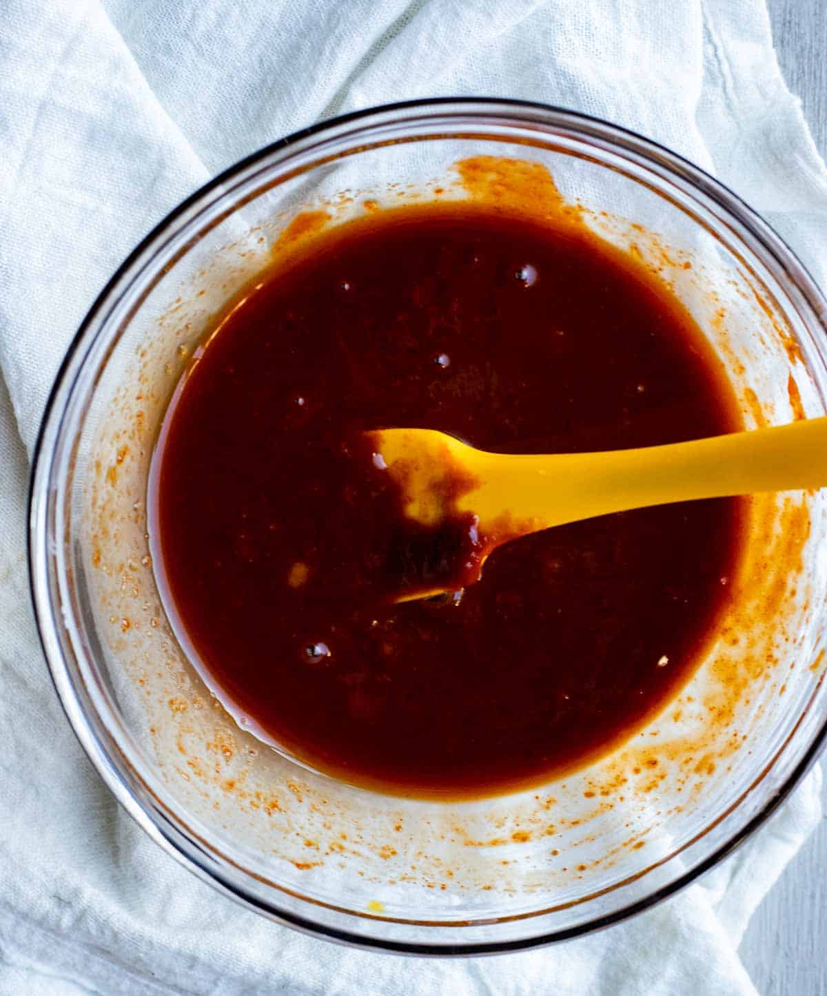 view of sauce in a glass bowl on a white napkin