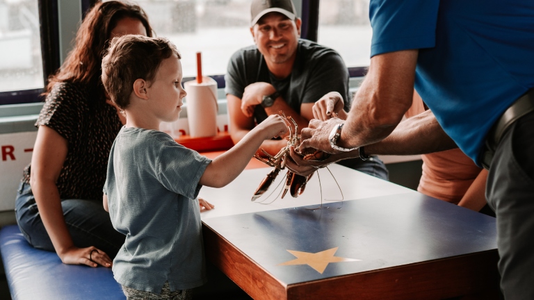 Family inspects lobster on Shediac Bay cruise