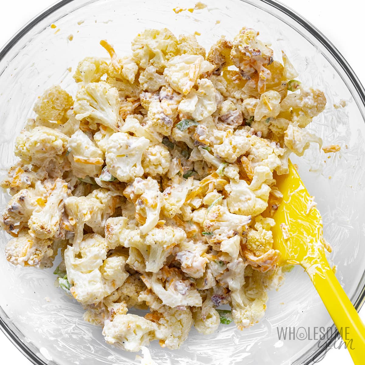 Cauliflower florets mixed with the sauce in a bowl.