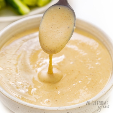 Tahini sauce drizzled from a spoon.