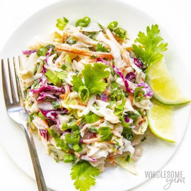 Mexican taco slaw plated with lime wedges and fresh cilantro.