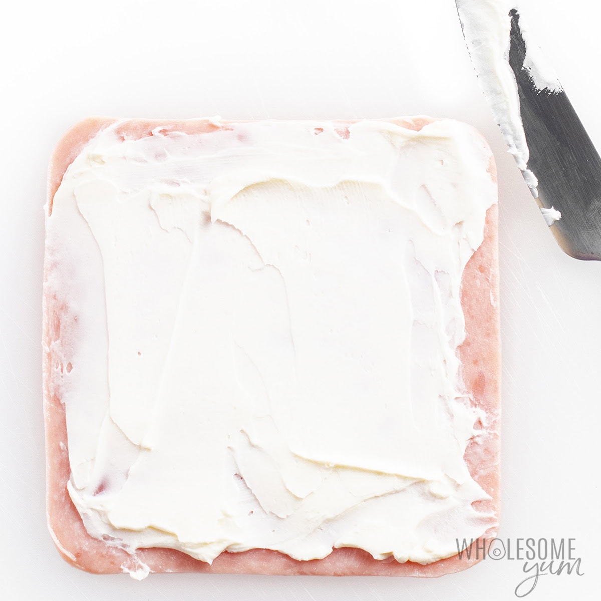 Cream cheese spread over a slice of ham.