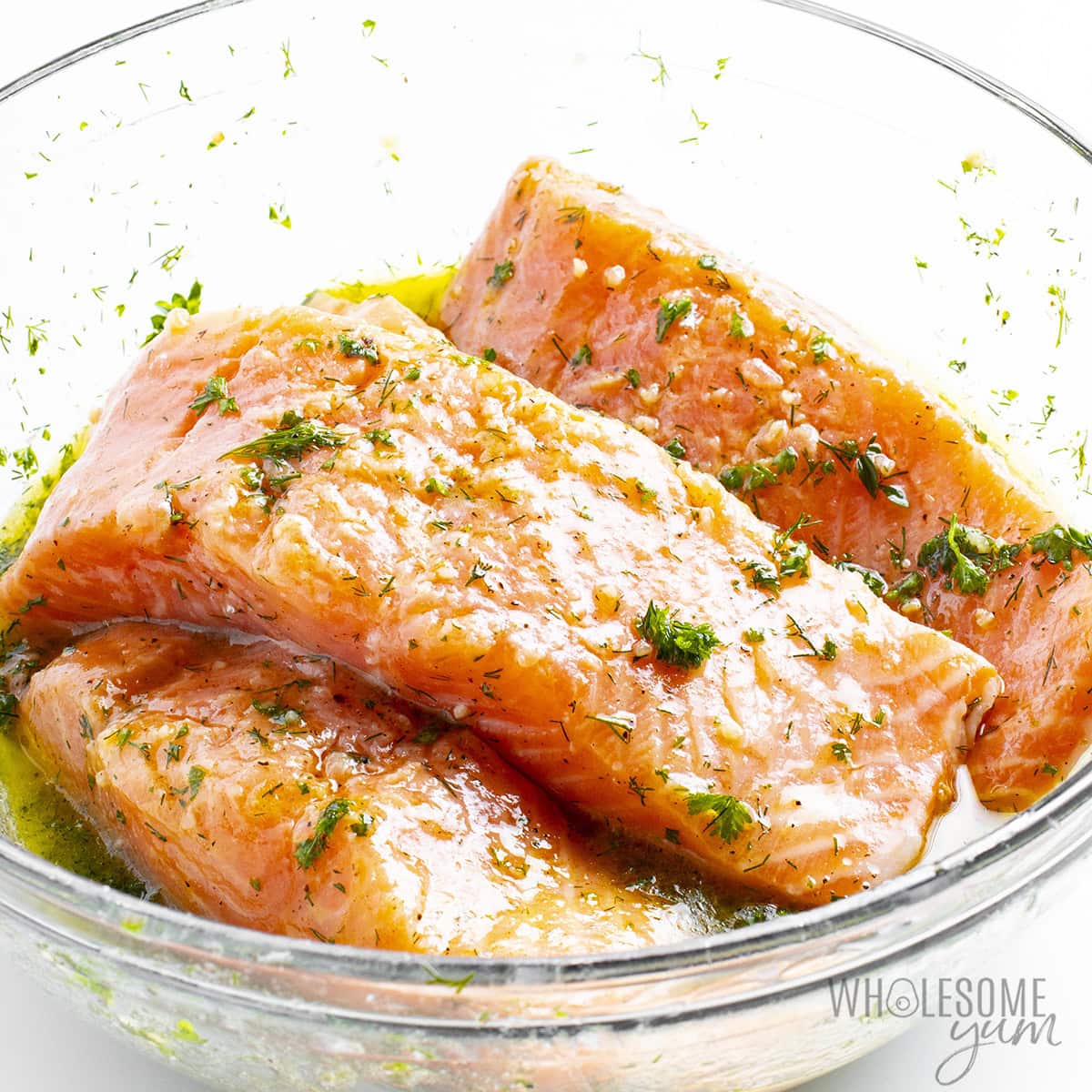 Marinated fish fillets in a glass bowl.