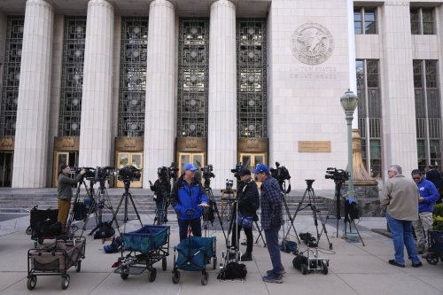 Members of the media gather for a morning news conference to discuss court filings related to the Palisades Fire investigation outside the U.S. Courthouse in downtown Los Angeles on Friday, Jan. 31, 2025. (AP Photo/Damian Dovarganes)