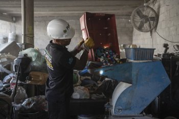 Jesus Cuevas, a Petgas technician, puts plastic caps into a shredding machine inside a recycling center in Boca del Rio, Veracruz, Mexico, Jan. 4, 2025. (AP Photo/Felix Marquez)