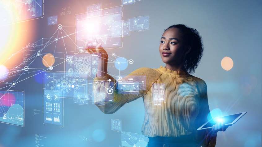 a woman looking at different pieces of technology data on multiple screens symbolizing the vast data available in patent information