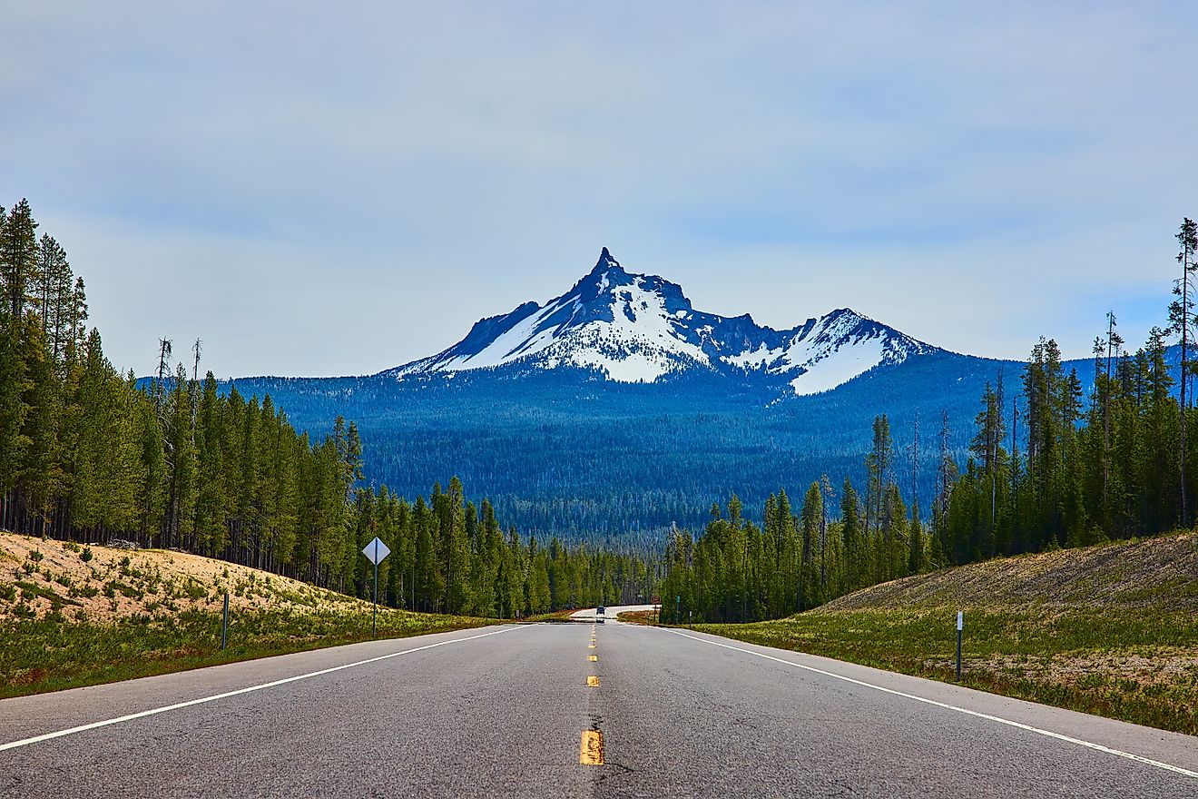 View of a snow-capped mountain from a highway along Crater Lake National Park in Oregon.