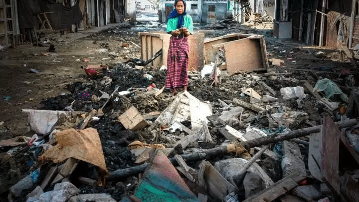 Due bambini camminano tra le macerie lasciate da uno tsunami, simbolo della devastazione causata dal disastro naturale.