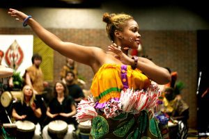 A woman dancing in front of drummers. 