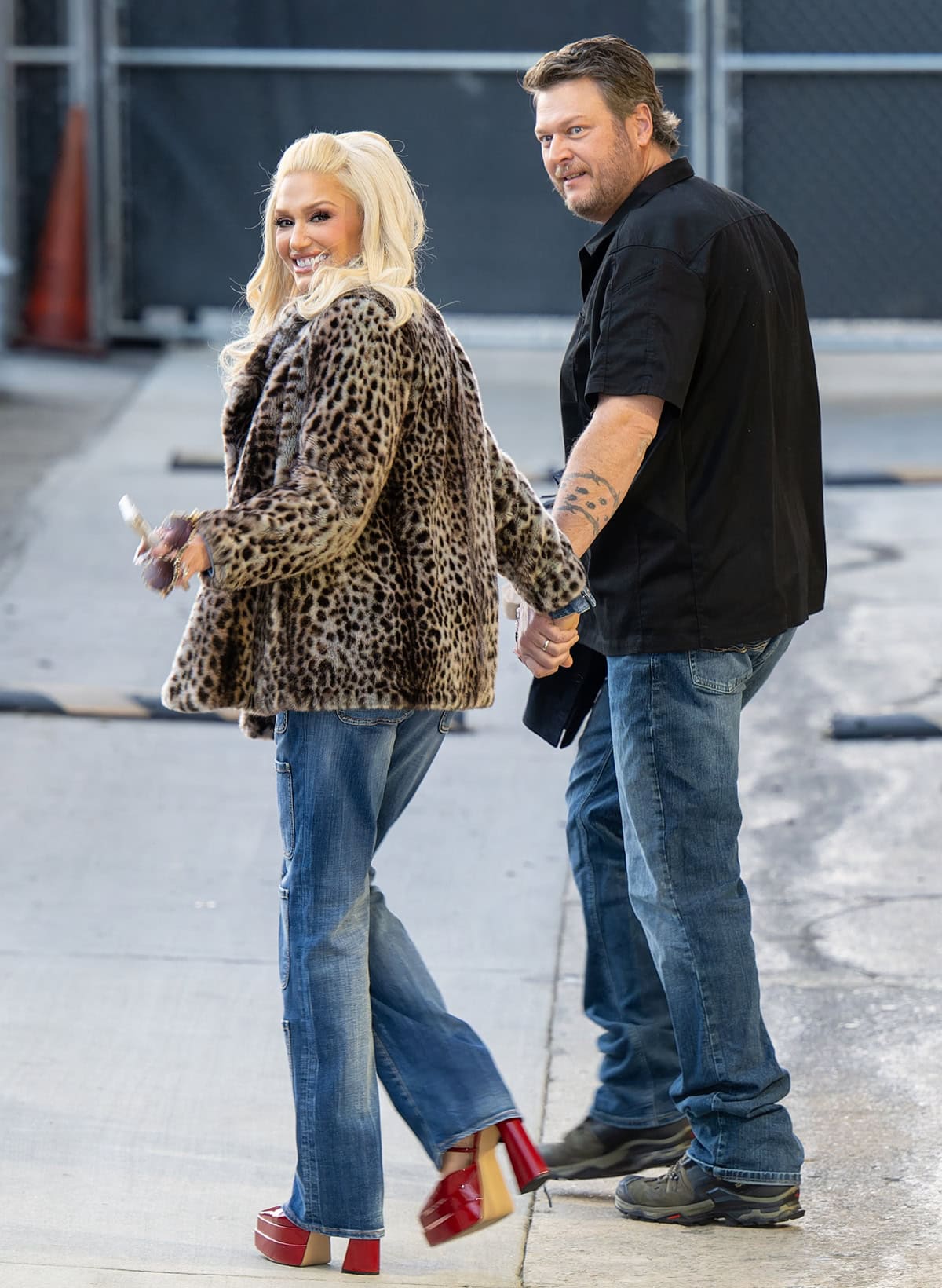 Gwen Stefani and Blake Shelton show off their laid-back style, with Gwen rocking a leopard print coat, flared jeans, and striking red platform heels while arriving at the Jimmy Kimmel show