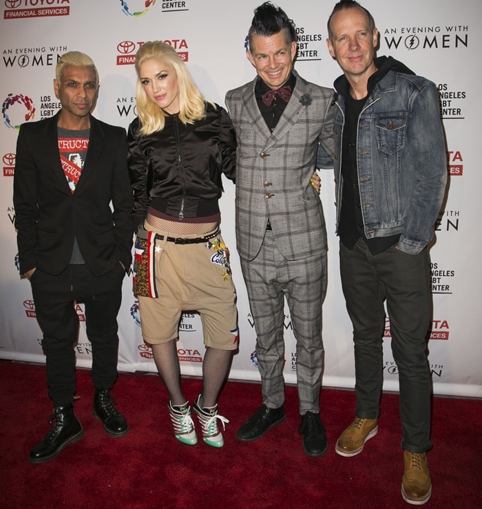 Gwen Stefani poses with her No Doubt bandmates at "An Evening with Women," blending her bold streetwear style with platform sneakers and embellished shorts alongside her casually stylish bandmates