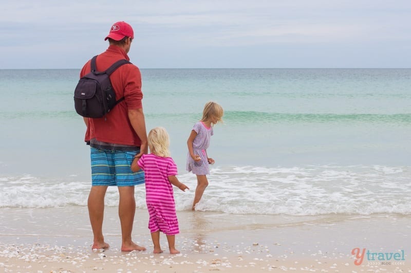 man and kids playing in beach