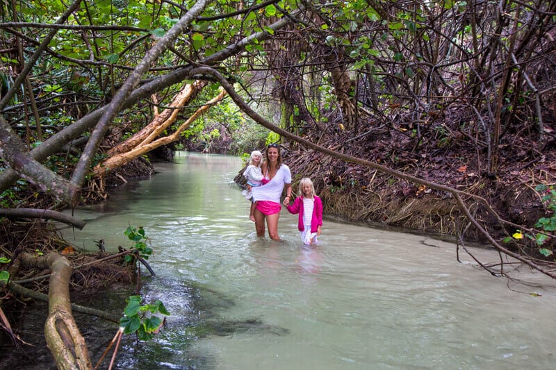 family standing in Eli Creek posing