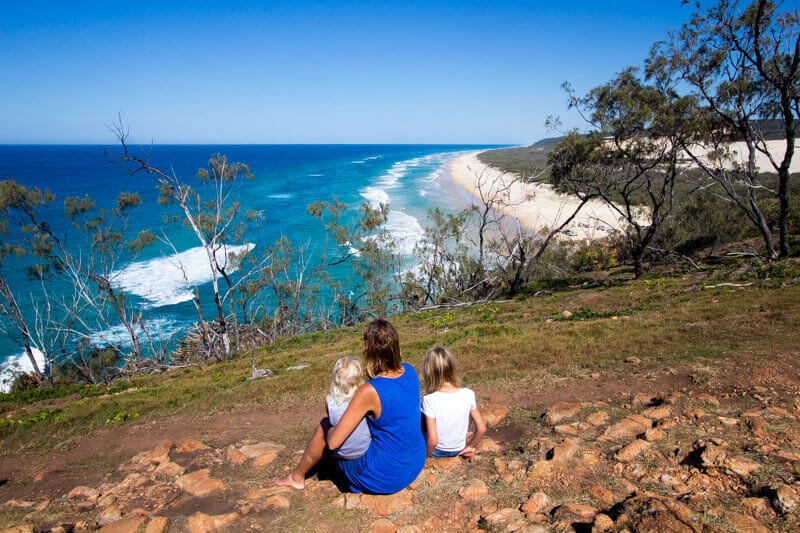 family sitting on rocks enjoying ocean views