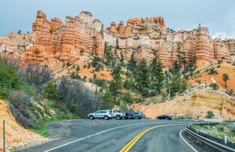 cars parked under orange hoodoos in Bryce Canyon national park