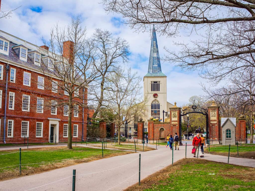 First Parish Church in Harvard Square and tourists in Harvard Yard in the campus of Harvard University,