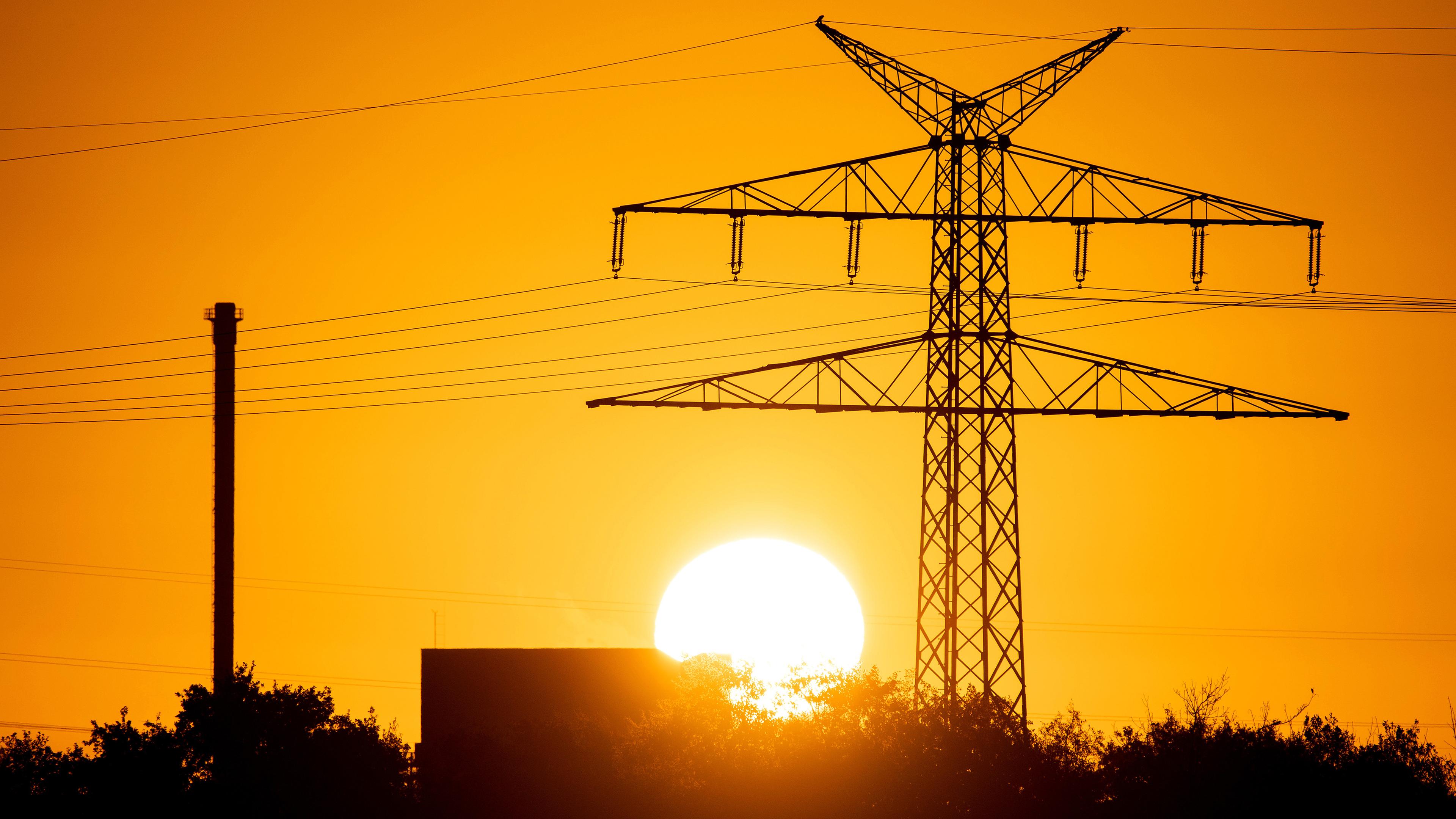 Die Sonne geht hinter einer Hochspannungsleitung an der Ems auf aufgenommen am 05.11.2022