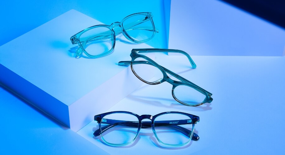 Three pairs of eyeglasses in various styles and colors, one with the brand name Zenni on the temple.