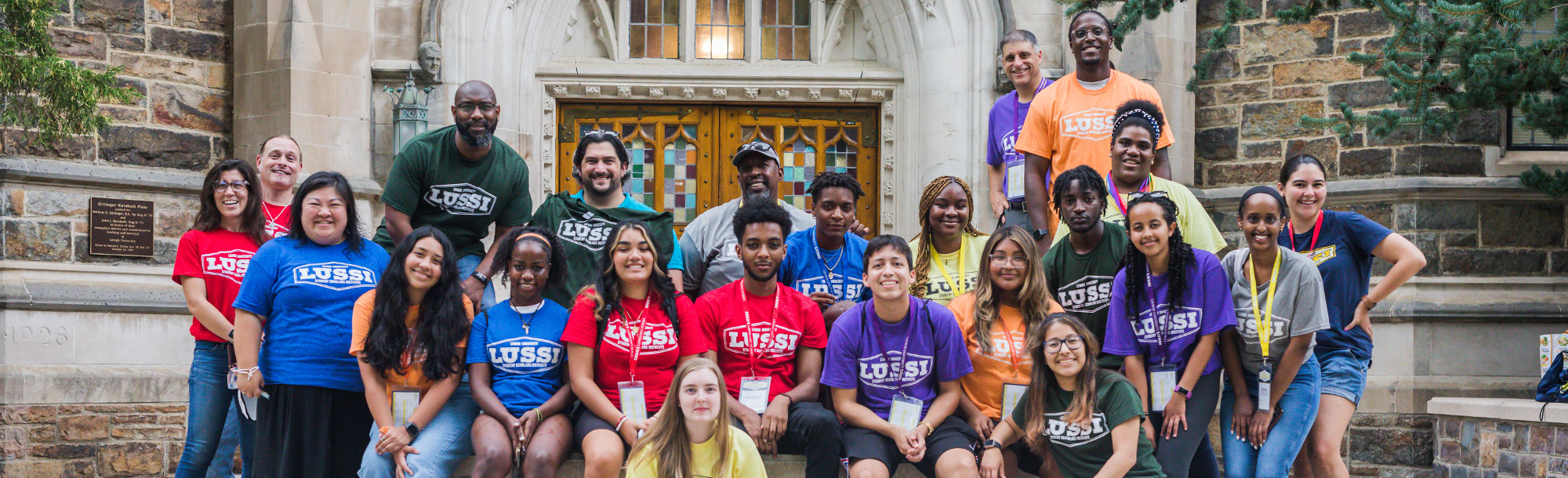 students with different colored shirts standing in group