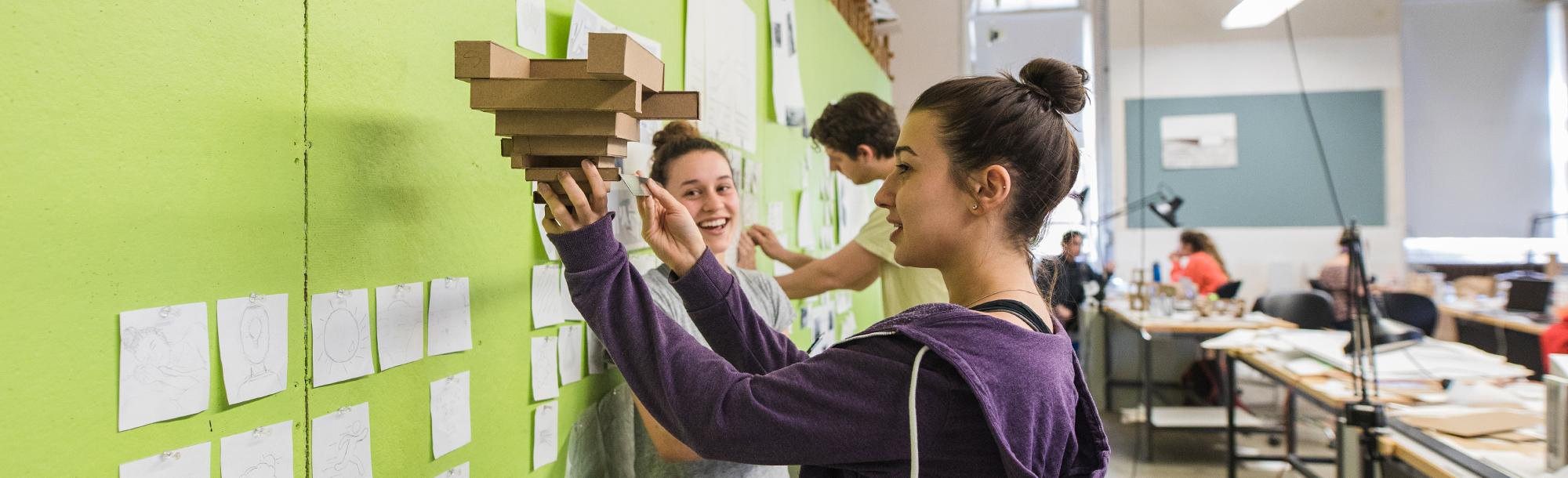 Two female students working on a cardboard model