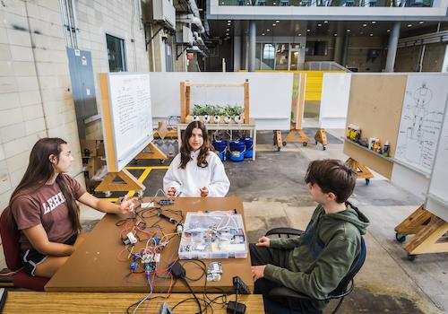 Three students working at a table